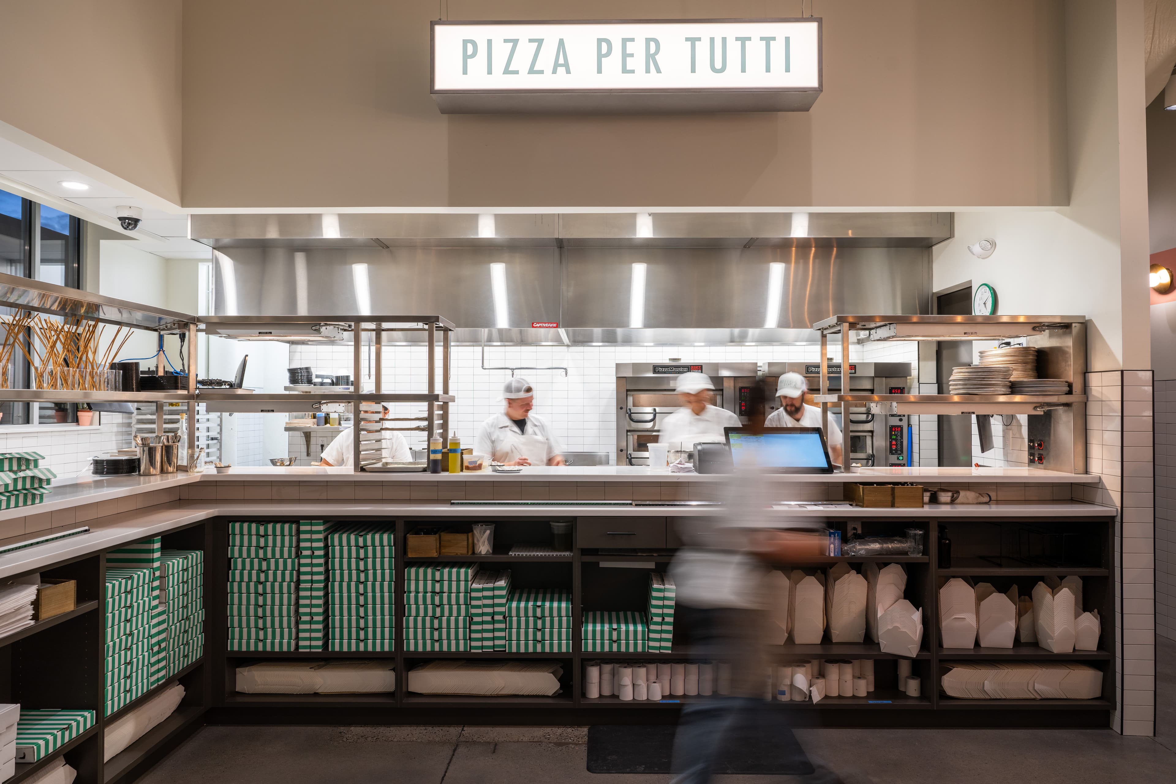 Pizzeria Luca kitchen staff and Pizza Per Tutti sign