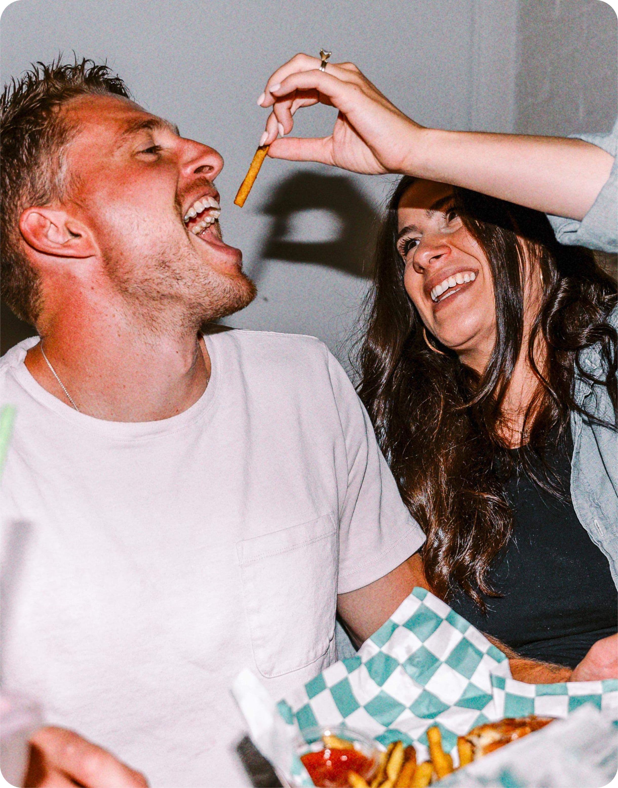 wife feeding husband a french fry